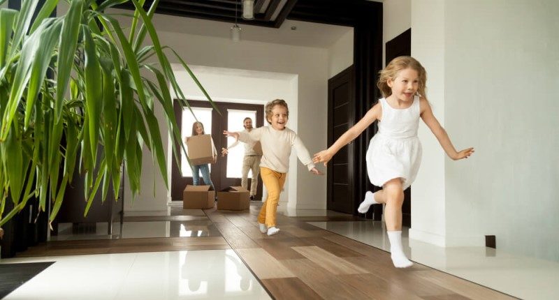 Children running ahead of their parents into a new house.