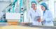people in hairnets looking at food on conveyer belt