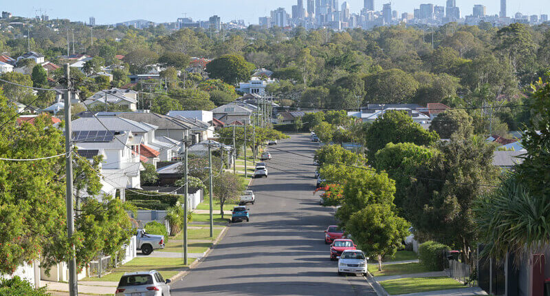 Residential houses street against Brisbane City skyline