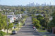 Residential houses street against Brisbane City skyline